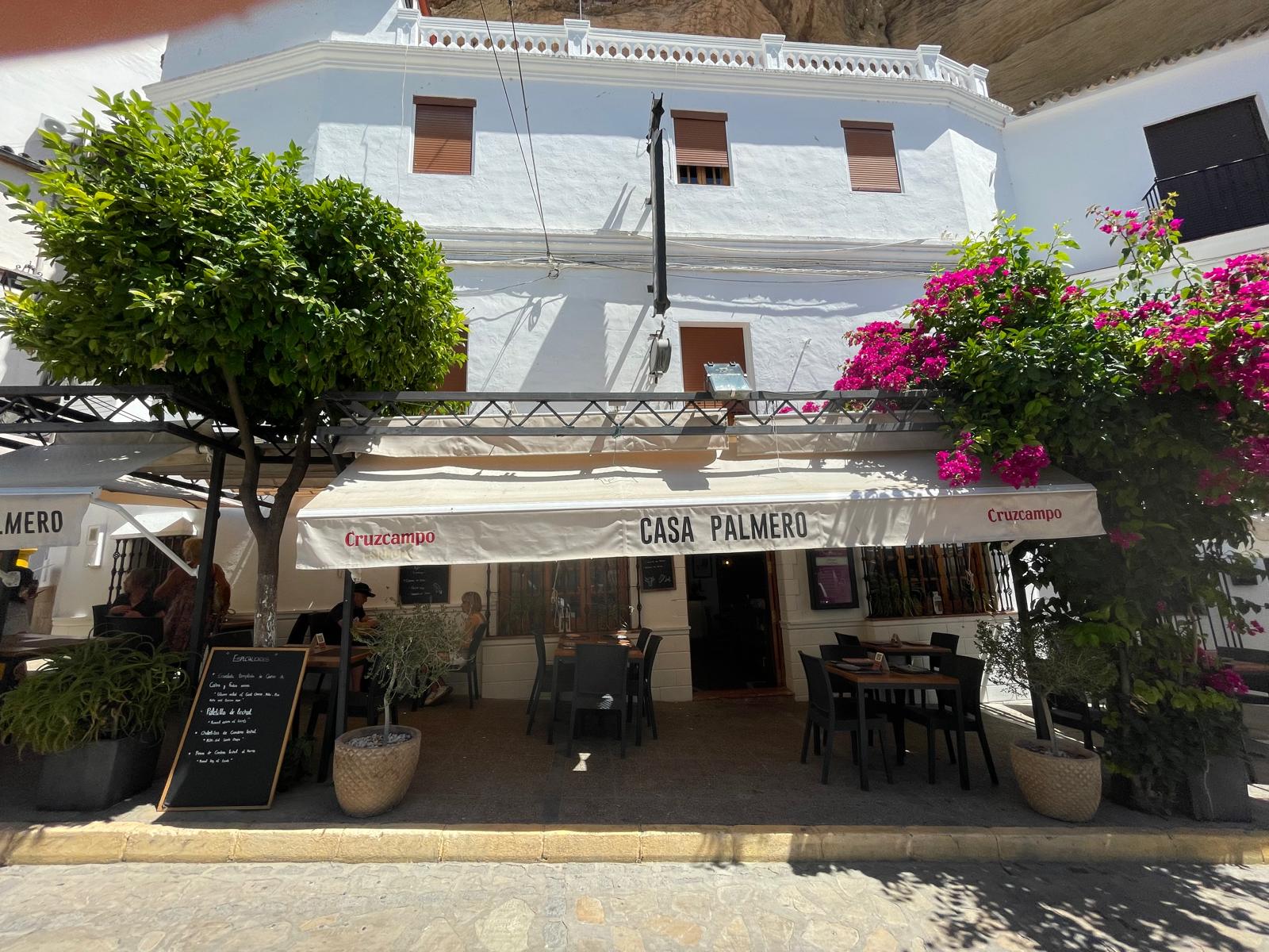 Terraza y fachada de Casa Palmero en Setenil de las Bodegas, bajo las casas colgadas de la roca